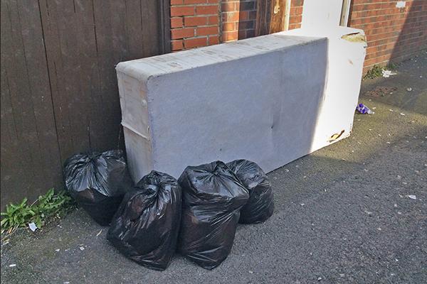 rubbish and bed in back lane