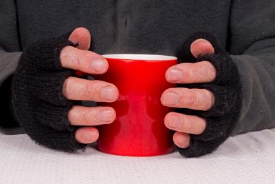 Warm Spaces mug Hands in gloves holding a hot drink