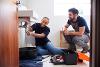Male and female apprentice plumbers fixing a sink