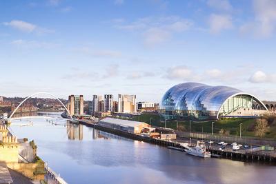 A picture of Gateshead Quayside showing the Millennium Bridge, Baltic Centre for Contemporary Art and the Glasshouse